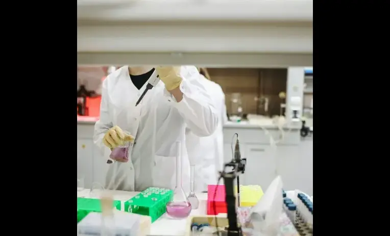Clinical lab scientist examining laboratory samples and reviewing diagnostic data in a professional medical testing facility.